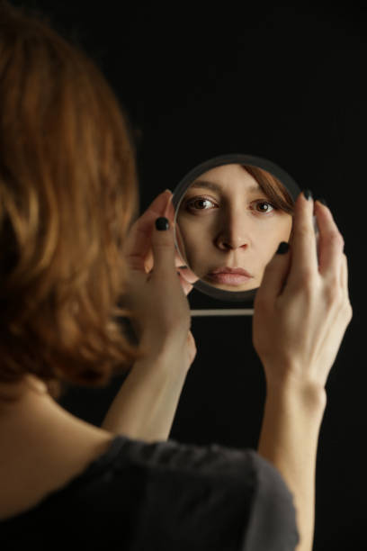 istock Mirror reflection of a woman's face, studio shot 1298959903