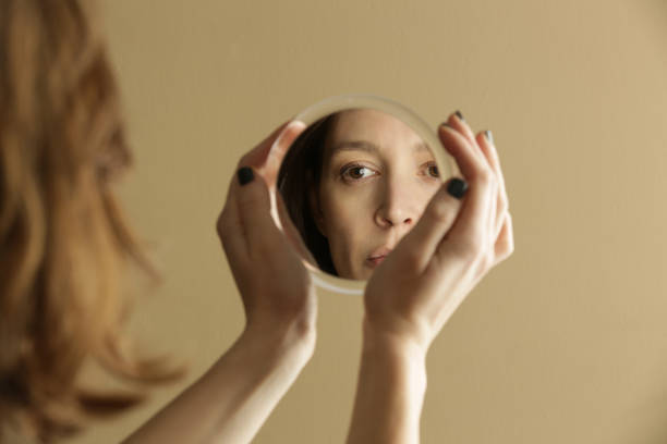 istock Mirror reflection of a woman's face, studio shot 1298959934