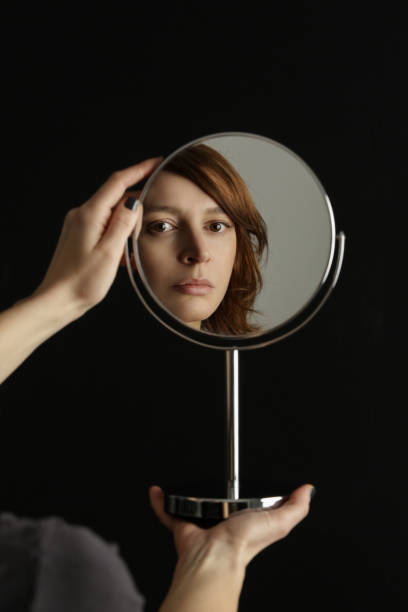 istock Mirror reflection of a woman's face, studio shot 1298959982