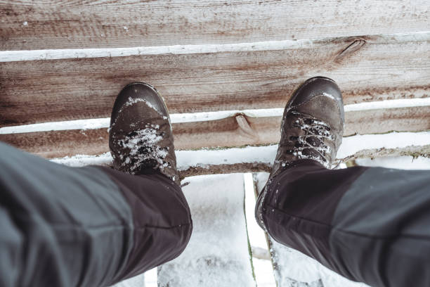 istock Trekking shoes on legs in the winter 1298960022