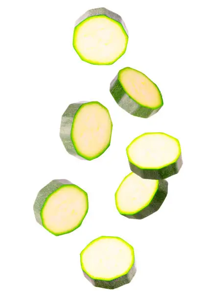 Isolated vegetables. Seven slices of zucchini in the air on white with clipping path as package design element. Full depth of field. Food levitation concept.