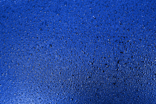 istock Small drops of water or condensation on a rich blue surface. Abstract background for a screen saver or backdrop 1298960406