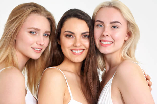 istock Group of happy different women in white hugging over white background. 1298960467