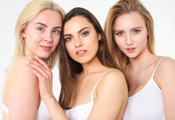 istock Group of happy different women in white hugging over white background. 1298960484