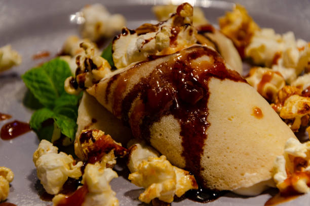 istock Stuffed pancake with sweet syrup, garnished with popcorn and mint 1298960565