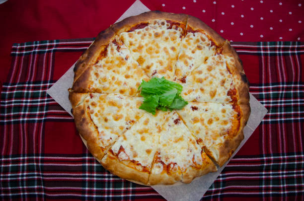 istock Pizza with cheese and herbs on the table 1298960585
