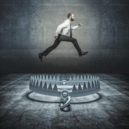 self-confident businessman jumps a big bear trap. concept of overcoming problems and adversity.