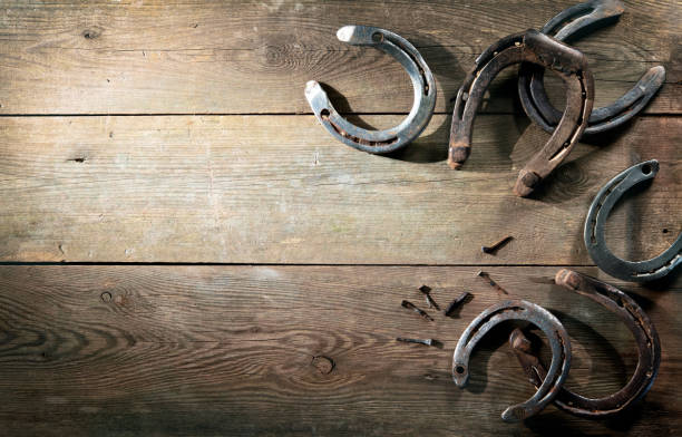 vieilles chaussures rouillées de cheval sur le plancher de grange - wild west horseshoe retro revival old fashioned photos et images de collection