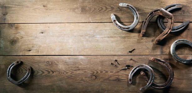 vieilles chaussures rouillées de cheval sur le plancher de grange - wild west horseshoe retro revival old fashioned photos et images de collection