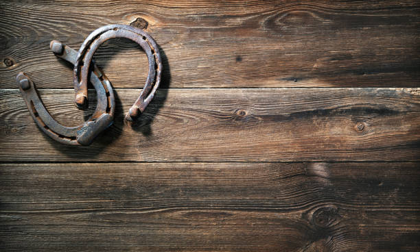 istock Two old rusty horse shoes on a rustic wooden 1298961387