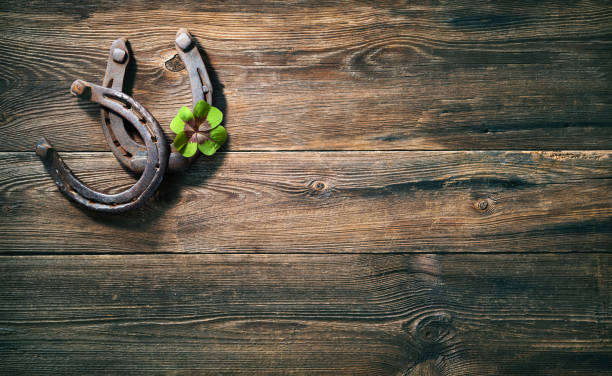 istock Two old rusty horse shoes and four leaf clover 1298961402