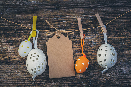 hanging white easter eggs with blank paper note, toned