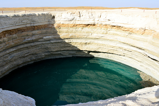 Karakum Desert north of Darvaza, Dashoguz Province, Turkmenistan: Turquoise crater - a water filled sinkhole in a natural gas field, the result of a collapsed cavern. The water is rich in sulphur. Turkmenistan holds the world's 4th largest natural gas reserves.