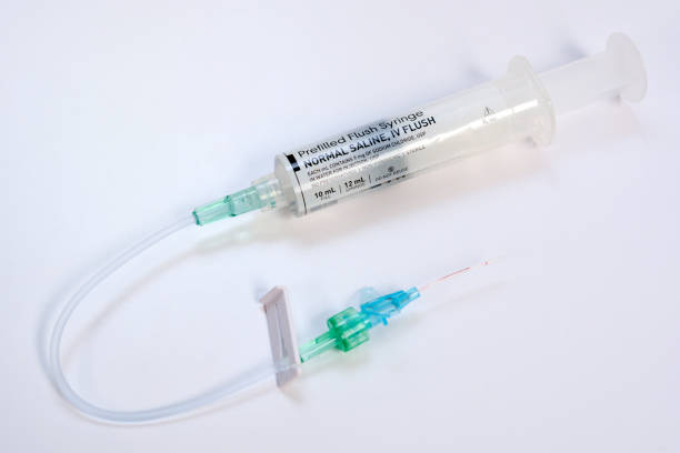 Used Saline Flash IV Catheter Used saline flush iv catheter on white background. saline drip stock pictures, royalty-free photos & images