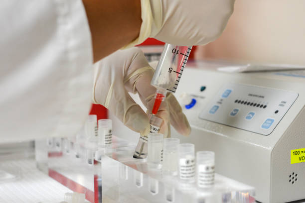 Doctor Drawing Up Stem Cells into Syringe Doctor drawing up mesenchymal stem cells from vials on counter into syringe. stem cell therapy stock pictures, royalty-free photos & images