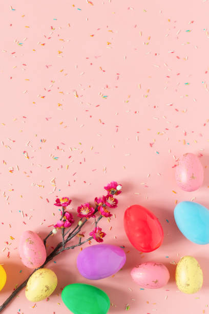istock Colorful Easter eggs on pastel pink background top view. 1298964092
