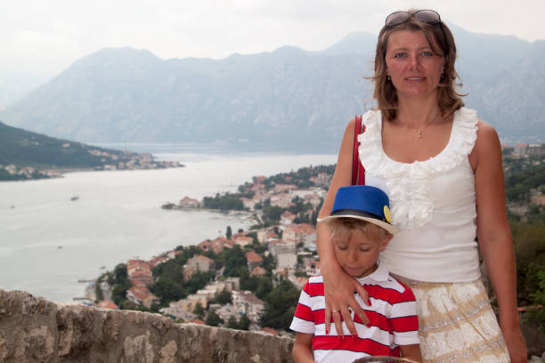 concept of family adventure. Mother traveling with children is d concept of family adventure. Mother traveling with children is depicted on the observation deck on the mountain overlooking the famous spectacular view of the Bay of Kotor, Montenegro east slavs photos stock pictures, royalty-free photos & images