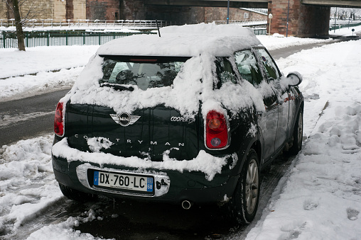 Mulhouse - France - 15 January 2021 - Rear view of black mini cooper D countryman covered by the snow parked in the street
