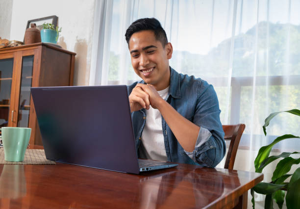 istock Young mexican latinx man using laptop at home 1298966855