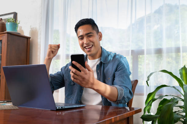 istock Young mexican latinx man using laptop and smartphone 1298966931