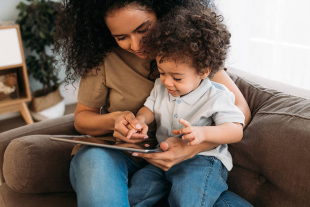 istock Young mother helping her little son with learning app 1298969227