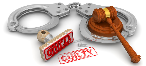 Wooden stamp and red imprint GUILTY with judge's hammer and handcuffs on white surface. 3D illustration