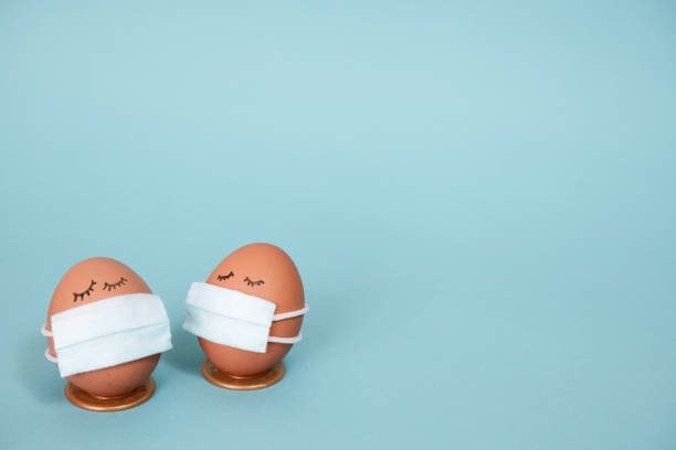 istock Easter eggs with COVID19 corona virus protection concepts. Easter eggs in a mask to decorate the Easter holidays. On a blue background with copyspace. 1298971744