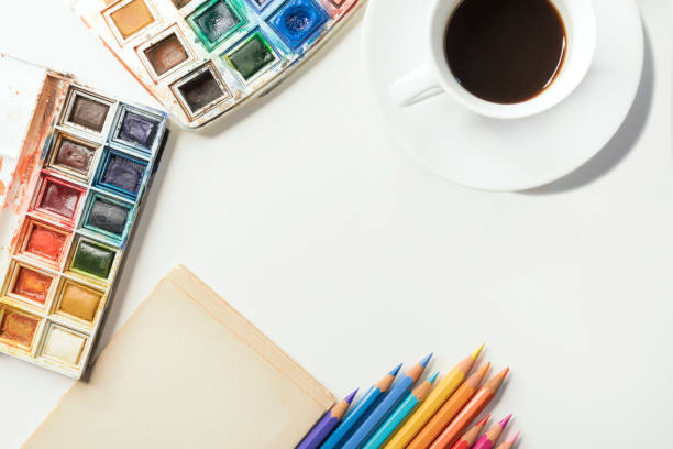 Art workplace, watercolor palette and colored pencils