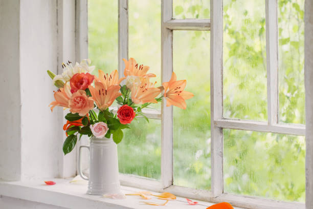 istock summer flowers in vase on background window with drops water 1298973184