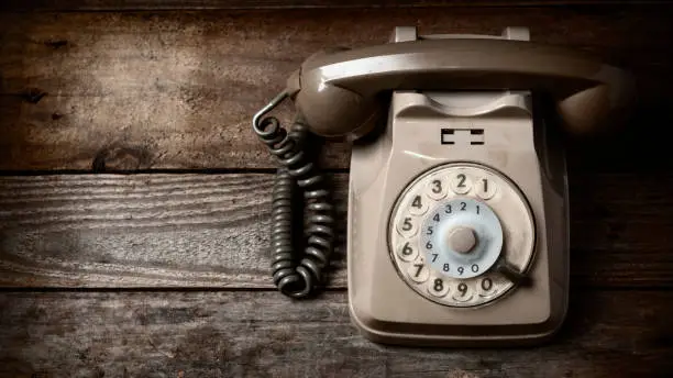 Retro disk telephone on a wooden table 16:9 ratio