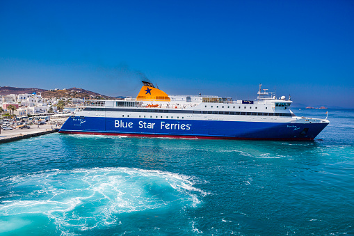 Paros island, Greece - July 03, 2018: In this picture, you can see the Blue Star Naxos ferry boarding and disembarking travelers and vehicles at the port of Paros Island in the Aegean Sea, Greece. Blue Star Naxos Ferry is a ferry owned and operated by Golden Star Ferries. These ferries sail in the Aegean Sea and also the Adriatic Sea.