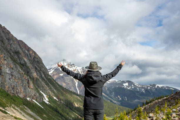 istock Young Woman with Arms Raised at Mount Edith Cavell, Alberta, Canada 1298976923