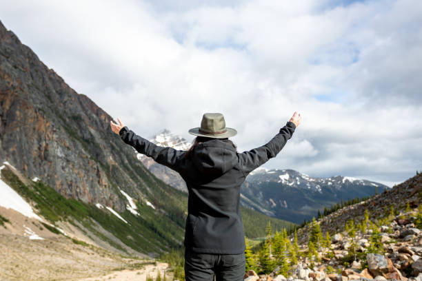 istock Young Woman with Arms Raised at Mount Edith Cavell, Alberta, Canada 1298977035