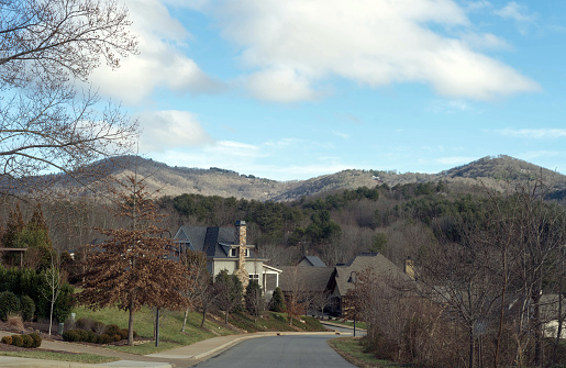 Asheville, NC, USA.  January 3, 2021.\nDriving through a residential area of Asheville, NC with the Appalachian Mountains in the background.  Focus is not on the house but on the scenery.  Winter season.