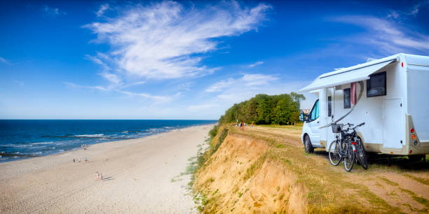 Vacations in Poland - motorhome over a cliff on the Baltic Sea Vacations in Poland - motorhome over a cliff on the Baltic Sea in Trzesacz, small tourist resort in west pomeranian voivodeship camper trailer stock pictures, royalty-free photos & images