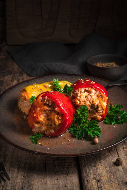 Stuffed pepper with parsley on a wooden background Stuffed pepper with parsley on a wooden background. Side view, vertical orientation. The concept of cooking. hungarian pepper stock pictures, royalty-free photos & images