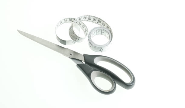 istock Pair of scissors and measuring tape on a white background 1298983702