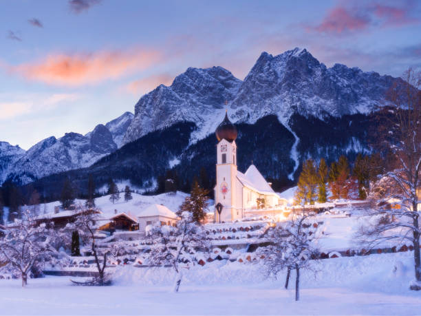 amanecer de invierno detrás de la hermosa iglesia en las montañas - pueblo de grainau, baviera - waxenstein fotografías e imágenes de stock