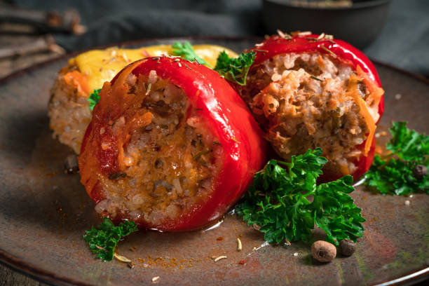 pepper with meat, rice and carrots decorated with parsley and spices in a brown plate - brown rice fotos imagens e fotografias de stock