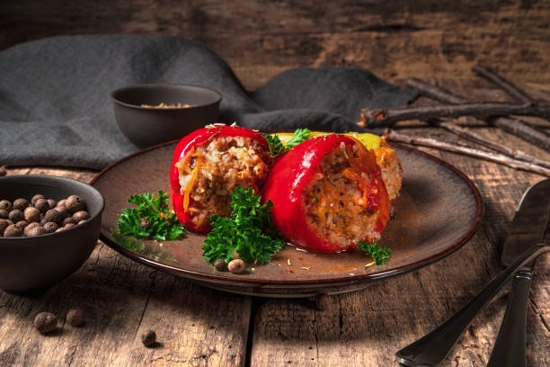 stuffed peppers in a plate on a wooden brown background - brown rice fotos imagens e fotografias de stock