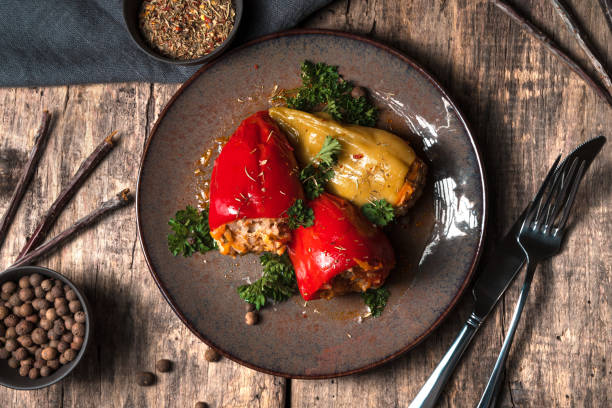 brown plate with bulgarian stuffed peppers and herbs on a wooden background - brown rice fotos imagens e fotografias de stock