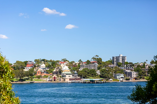 Town skyline, with bay of water, Balmain suburb of Sydney, blue sky background with copy space, full frame horizontal composition