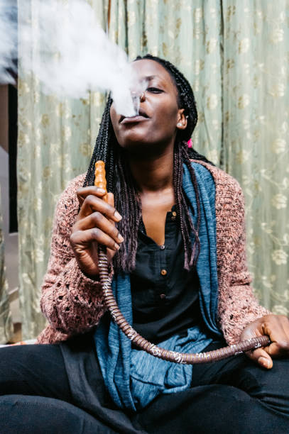 black woman is exhaling hookah smoke - braids african descent women pensive imagens e fotografias de stock