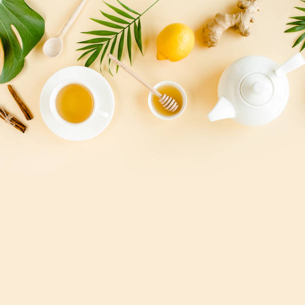 istock Herbal tea with mint, ginger, lemon, honey and other herbs on yellow background. Flat lay, top view 1298987949