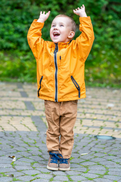 happy smiling caucasian kid standing on pavement in park with hans up - 5515 imagens e fotografias de stock