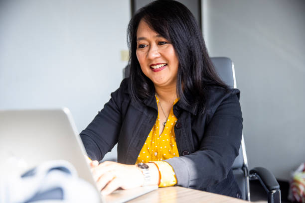 mujer asiática madura trabajando - filipino fotografías e imágenes de stock