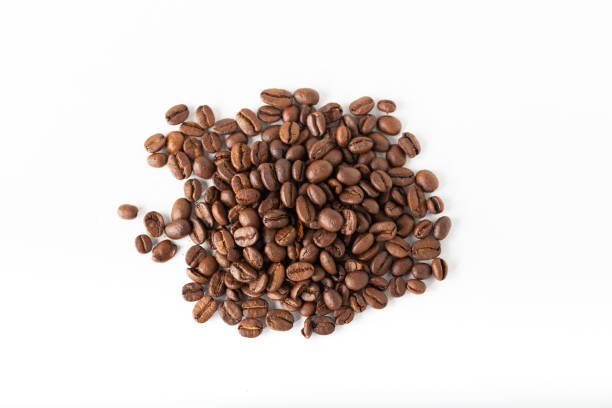 pile de grains de café sur une surface blanche. fond et texture. vue du haut. - bean coffee bean heap white photos et images de collection