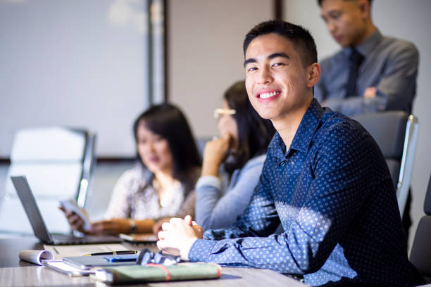 joven empresario asiático sonriendo a la cámara - filipino fotografías e imágenes de stock