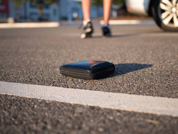 istock A man walking away after losing his wallet on a parking. 1298990201