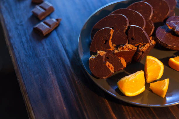 Madrid, Spain. December 28, 2020. orange cookies covered with chocolates on wooden table